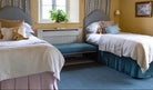 Two beds in a bedroom with yellow walls, a window, and decorative items. Bed Valances in Pink and Teal. Children's twin bedroom. 